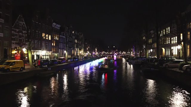 AMSTERDAM, NETHERLANDS - JANUARY 02, 2017: Cruise boat in night canals of Amsterdam. Time Lapse. January 02, 2017 in Amsterdam - Netherland.