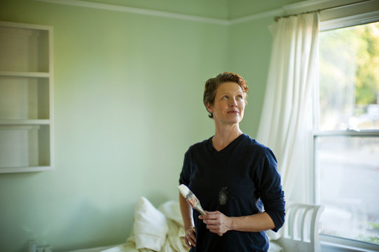 Woman repainting a room in her house.