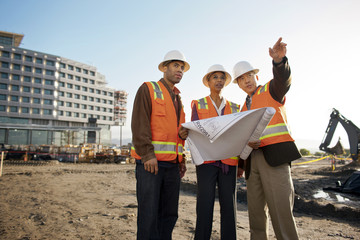 Architect discussing building plans together at construction site