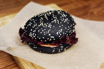 black burger. serving cheeseburger or hamburger with salad on wo