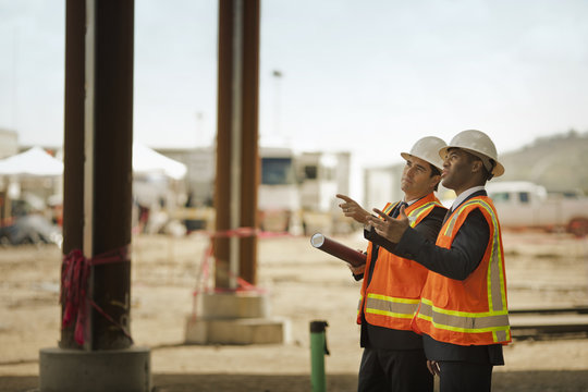 Two business colleagues discussing a project on a construction site.