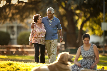 Smiling mature couple walking though a park.