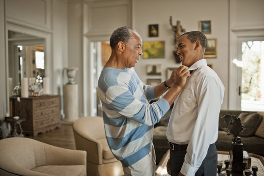 Father helping son to wear the nacktie at home