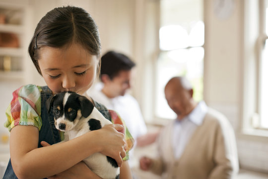 Young girl holding a puppy.