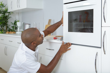 Man fitting oven into new kitchen