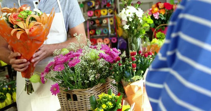 Florist giving bouquet of flower to customer in flower shop