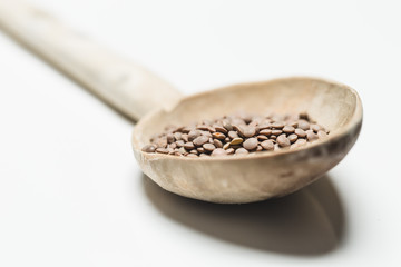 Berglinsen mit Holzlöffel auf weissem Hintergrund