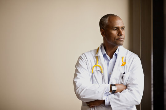 Thoughtful male doctor looking away - Powered by Adobe