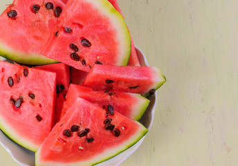 Chunks of watermelon with big seeds lying on a plate