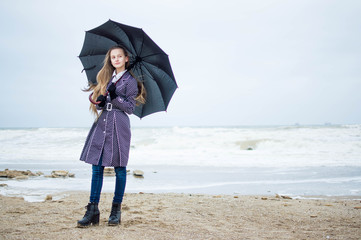 Girl with umbrella on the cloudy sea