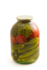 Pickled cucumber and tomato in glass jar isolated