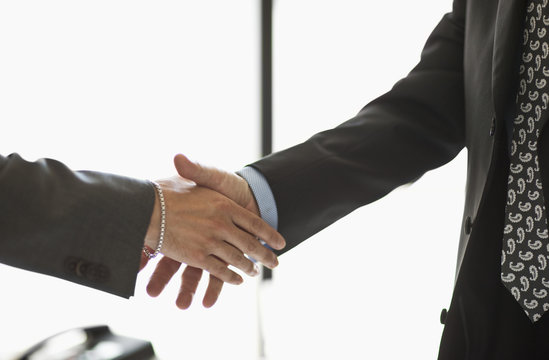 Two businessmen shake hands.