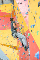 Obraz premium Man climbing indoor wall