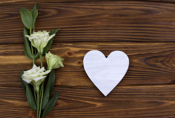 White wooden heart with flowers on brown background. Valentine Day. Greeting Card. Wedding.