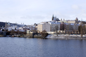 Snowy freeze Prague Lesser Town with gothic Castle above River Vltava, Czech republic