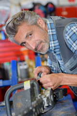 Portrait of mechanic working on hedge trimmer