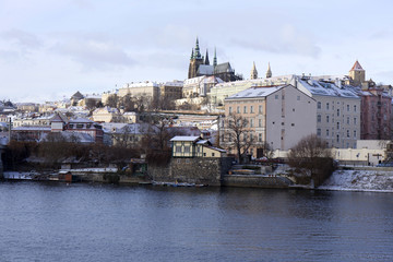 Snowy freeze Prague Lesser Town with gothic Castle above River Vltava, Czech republic