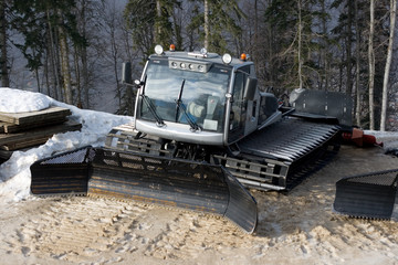 View of a small shining snow tracktor to level snow and help sportsmen