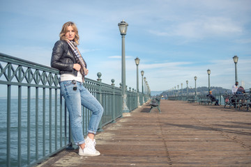 Young confident woman standing on wooden bridge