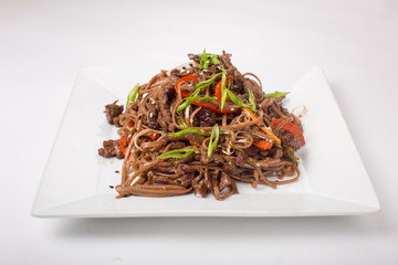 Buckwheat noodles with chicken teriyaki on a white background