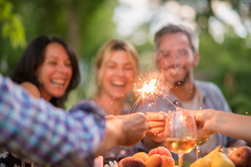 On a terrace friends enjoy themselves by lighting spark sticks