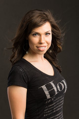 Young caucasian woman with brown hair and a black top smiles at the viewer