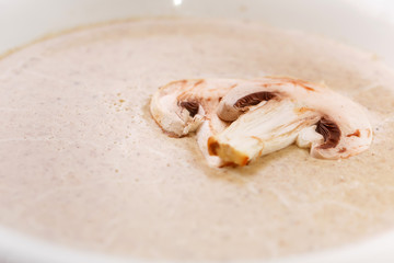 Cream soup with mushrooms on a white plate