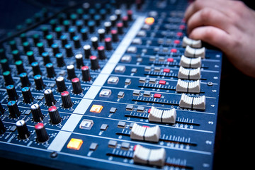 Sound manager is working on the audio mixer, preparing new mix of a song or work on live event