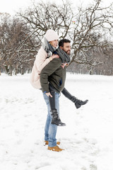Fototapeta na wymiar Loving couple enjoying the snow in the park