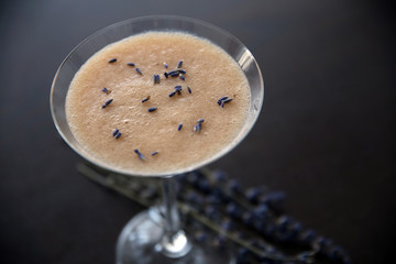 Mixed fruit juice in cocktail glass with lavender on table