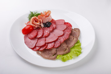 thin slices of sausage and meat on a plate   white background
