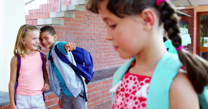 Slow motion of schoolkid bullying a sad girl in corridor at school 4k