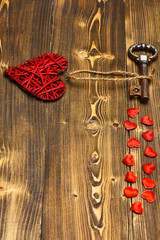 red heart and metallic key on wood as valentines decoration