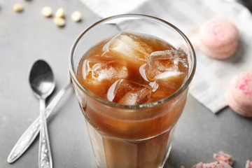 Glass of cold coffee with milk on table, closeup