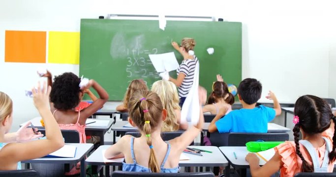School kids throwing paper balls on teacher while teaching in classroom at school 4k