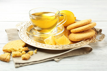 Composition with cookies, green tea and lemons on tray