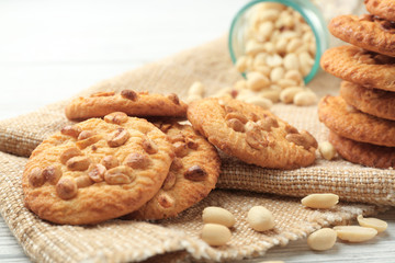 Obraz na płótnie Canvas Composition with delicious peanut cookies, nuts on sackcloth