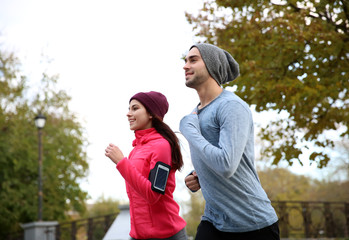 Young couple running in beautiful autumn park