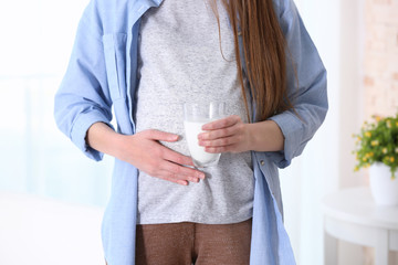 Fototapeta na wymiar Pregnant woman with glass of milk at home, closeup