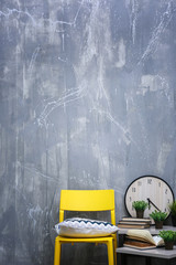 Modern interior design with yellow chair and little table on grey background