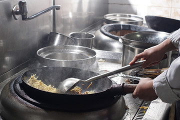 Close up of working chef preparing chinese food