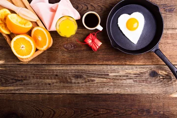Photo sur Plexiglas Oeufs sur le plat Heart shape fried egg, fresh orange juice and coffee. Top view