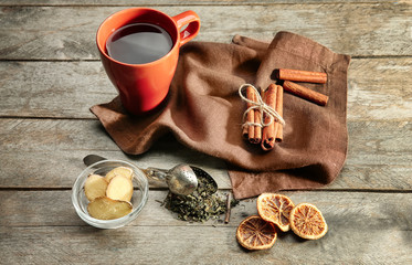 Hot tea with aromatic ingredients on wooden background