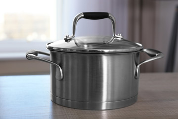 Metal saucepan on table in kitchen