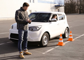 Young woman passing driving license exam outdoors
