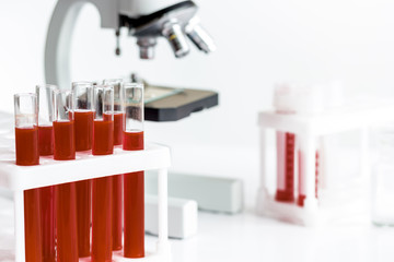 blood in glass tubes on background of microscope