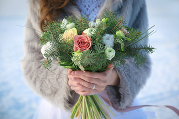 Beautiful bride with bouquet outdoors on winter day, closeup