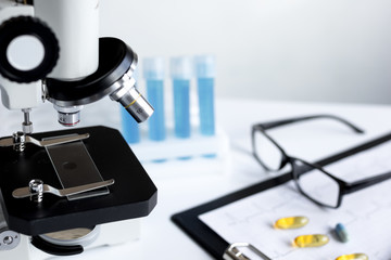 doctors desk with microscope and test tubes