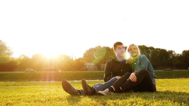 Love couple sitting on grass in summer park