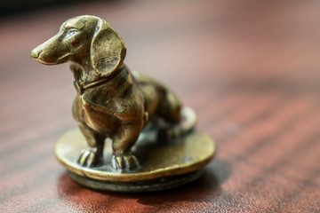 Brass dachshund atop a desk.